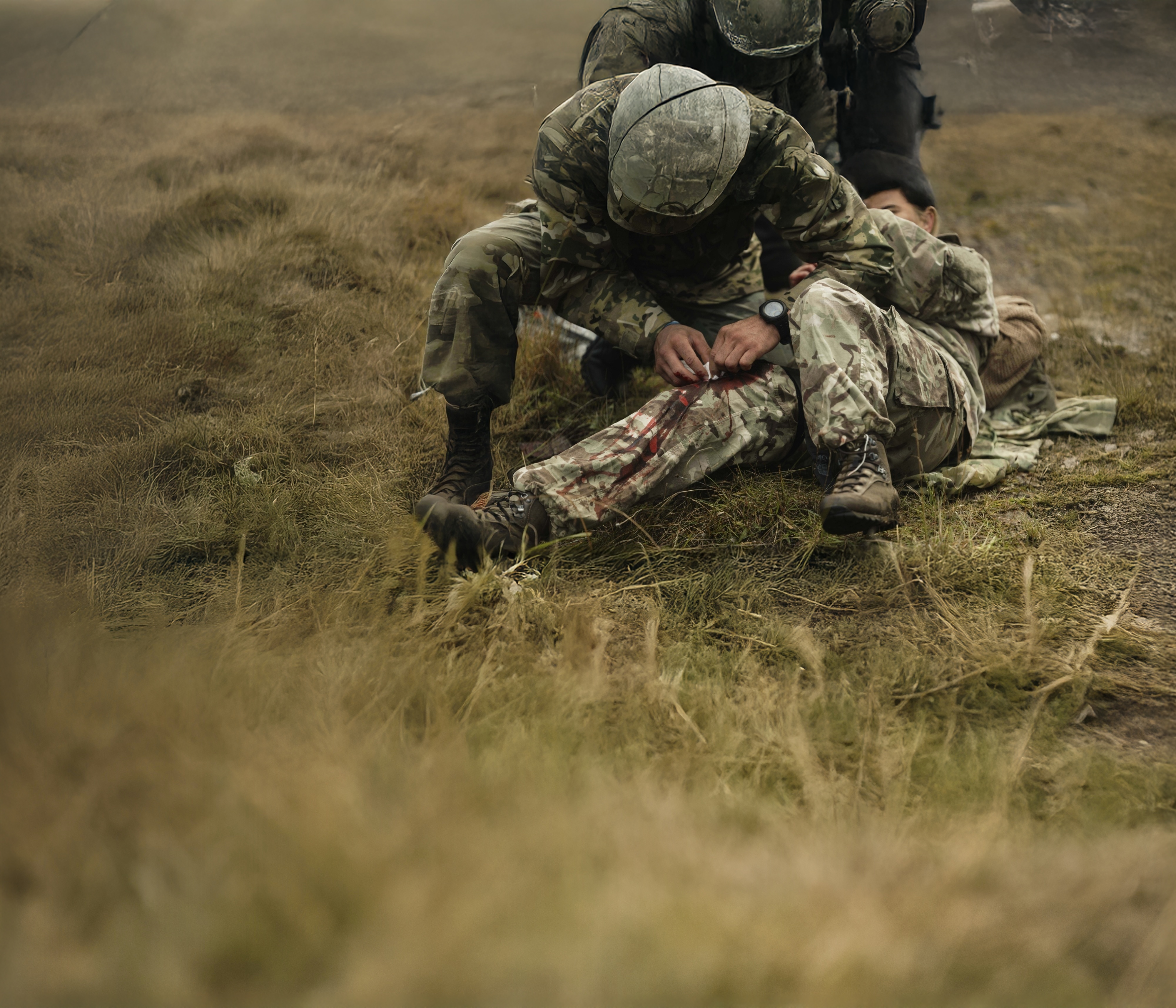 Tactical soldier in field applying medical aid